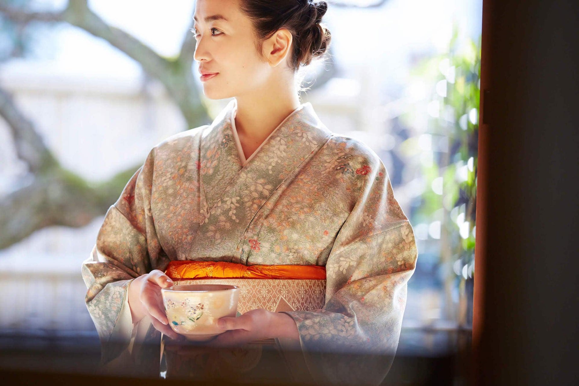 Woman in kimono holding chawan